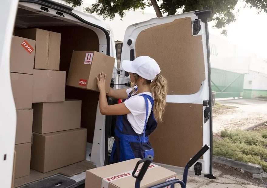 Kartons werden sorgfältig in einen Transporter geladen